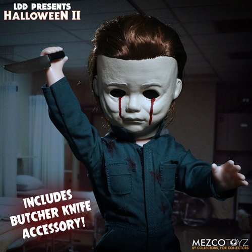 This is a Halloween II Michael Myers Living Dead Doll that is standing in a hospital and he has blood tears coming out of a white mask and is holding a knife while wearing green coveralls